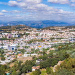 Dados da estação da Circular Sul revelam redução acentuada de dióxido de azoto; valores situam-se agora abaixo do limite legal para a proteção da saúde A qualidade do ar em Braga apresenta uma evolução muito positiva, consolidando uma tendência de melhoria que é particularmente visível nas zonas de maior pressão rodoviária. Segundo os dados mais recentes da estação de monitorização da Avenida Frei Bartolomeu dos Mártires (Circular Sul), a concentração média anual de dióxido de azoto (NO₂) sofreu uma redução de 25% entre 2024 e 2025. O valor baixou dos 42 µg/m³ para os 31 µg/m³, fixando-se confortavelmente abaixo do limite legal de 40 µg/m³. Para o vice-presidente da autarquia, Altino Bessa, estes resultados são o reflexo direto das políticas de sustentabilidade e mobilidade implementadas pelo Município de Braga ao longo da última década, confirmando que a aposta no transporte público e nos modos suaves está a dar frutos concretos. A avaliação do ar na cidade é feita através de um sistema dual que garante total transparência e precisão dos dados: Rede Regional: Braga integra a Rede de Monitorização da Qualidade do Ar da CCDR-Norte, com estações urbanas de tráfego que medem o impacto direto da circulação automóvel. Rede Municipal: O concelho dispõe ainda de um sistema próprio, operado pela Monitar, com 12 estações estrategicamente distribuídas para assegurar uma leitura contínua e detalhada de todo o território. Além do NO₂, os indicadores relativos às partículas finas (PM10 e PM2,5) mantiveram-se também abaixo dos limites legais em todas as estações do concelho durante o ano de 2025, reforçando a segurança ambiental para os bracarenses. Esta melhoria atmosférica não é um evento isolado, mas o resultado de uma estratégia integrada que inclui o reforço da rede de ciclovias, a modernização da frota dos TUB – Transportes Urbanos de Braga e a criação de novas zonas verdes. A reorganização da circulação urbana tem permitido aliviar os pontos de maior congestionamento, reduzindo as emissões nos principais eixos de entrada da cidade. O Município reafirma o seu compromisso em continuar a adaptar o planeamento urbano às exigências da Agência Europeia do Ambiente, focando-se na eficiência energética e na proteção da saúde dos cidadãos como pilares do desenvolvimento local.