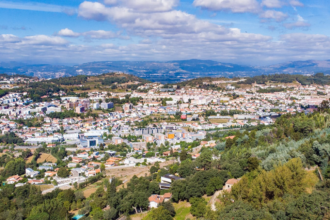 Dados da estação da Circular Sul revelam redução acentuada de dióxido de azoto; valores situam-se agora abaixo do limite legal para a proteção da saúde A qualidade do ar em Braga apresenta uma evolução muito positiva, consolidando uma tendência de melhoria que é particularmente visível nas zonas de maior pressão rodoviária. Segundo os dados mais recentes da estação de monitorização da Avenida Frei Bartolomeu dos Mártires (Circular Sul), a concentração média anual de dióxido de azoto (NO₂) sofreu uma redução de 25% entre 2024 e 2025. O valor baixou dos 42 µg/m³ para os 31 µg/m³, fixando-se confortavelmente abaixo do limite legal de 40 µg/m³. Para o vice-presidente da autarquia, Altino Bessa, estes resultados são o reflexo direto das políticas de sustentabilidade e mobilidade implementadas pelo Município de Braga ao longo da última década, confirmando que a aposta no transporte público e nos modos suaves está a dar frutos concretos. A avaliação do ar na cidade é feita através de um sistema dual que garante total transparência e precisão dos dados: Rede Regional: Braga integra a Rede de Monitorização da Qualidade do Ar da CCDR-Norte, com estações urbanas de tráfego que medem o impacto direto da circulação automóvel. Rede Municipal: O concelho dispõe ainda de um sistema próprio, operado pela Monitar, com 12 estações estrategicamente distribuídas para assegurar uma leitura contínua e detalhada de todo o território. Além do NO₂, os indicadores relativos às partículas finas (PM10 e PM2,5) mantiveram-se também abaixo dos limites legais em todas as estações do concelho durante o ano de 2025, reforçando a segurança ambiental para os bracarenses. Esta melhoria atmosférica não é um evento isolado, mas o resultado de uma estratégia integrada que inclui o reforço da rede de ciclovias, a modernização da frota dos TUB – Transportes Urbanos de Braga e a criação de novas zonas verdes. A reorganização da circulação urbana tem permitido aliviar os pontos de maior congestionamento, reduzindo as emissões nos principais eixos de entrada da cidade. O Município reafirma o seu compromisso em continuar a adaptar o planeamento urbano às exigências da Agência Europeia do Ambiente, focando-se na eficiência energética e na proteção da saúde dos cidadãos como pilares do desenvolvimento local.