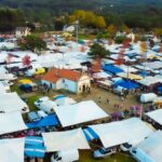 Vista aérea das tendas da Feira dos Santos de Cerdal à volta de uma capela